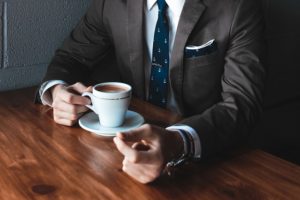 image of a man in suit drinking coffee